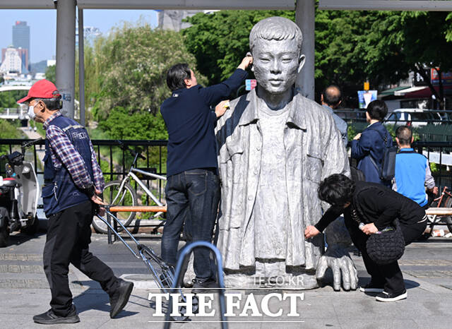 노동절을 하루 앞둔 30일 서울 종로구 청계천로 전태일다리를 찾은 시민들이 전태일 동상의 얼굴을 닦고 있다. /이새롬 기자
