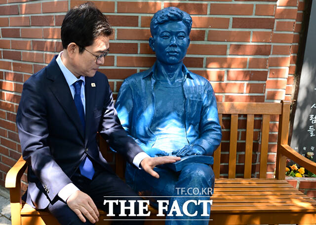 정원오 더불어민주당 서울시장 후보가 노동절을 하루 앞둔 30일 서울 종로구 청계천로 아름다운청년 전태일기념관 앞에서 노동공약을 발표한 뒤 전태일 동상을 쓰다듬고 있다.