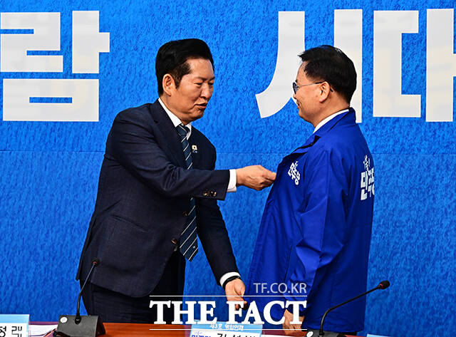 정청래 더불어민주당 대표(왼쪽)가 30일 오전 서울 여의도 국회에서 열린 3차 인재영입식에 참석해 6.3 재보궐선거 제주 서귀포시 후보로 영입한 김성범 전 해수부 차관에게 파란색 점퍼를 입혀주고 있다. /국회=배정한 기자