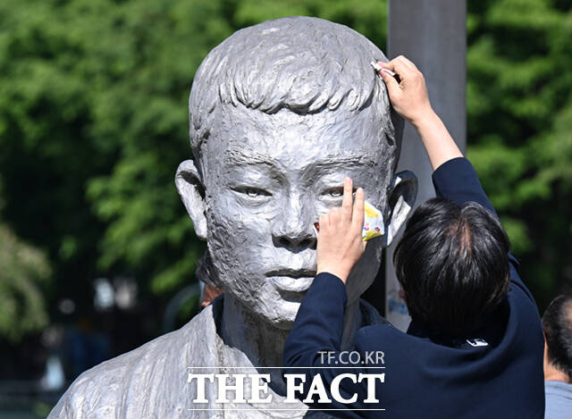 노동절을 하루 앞둔 30일 서울 종로구 청계천로 전태일다리를 찾은 시민들이 전태일 동상의 얼굴을 닦고 있다. /이새롬 기자