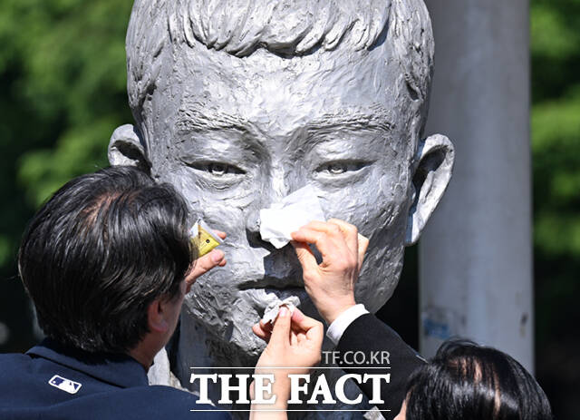 노동절을 하루 앞둔 30일 서울 종로구 청계천로 전태일다리를 찾은 시민들이 전태일 동상의 얼굴을 닦고 있다. /이새롬 기자