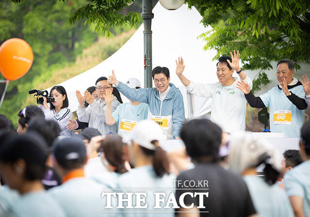 마라톤 대회 참석해 시민들에게 인사하는 정원오 더불어민주당 서울시장 후보와 오세훈 국민의힘 서울시장 후보(왼쪽 네 번째부터). /정원오 캠프