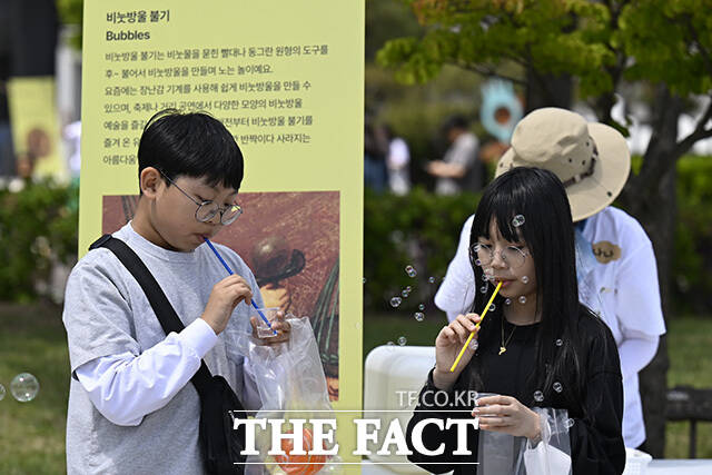 어린이들이 팽이치기를 하고 있다.