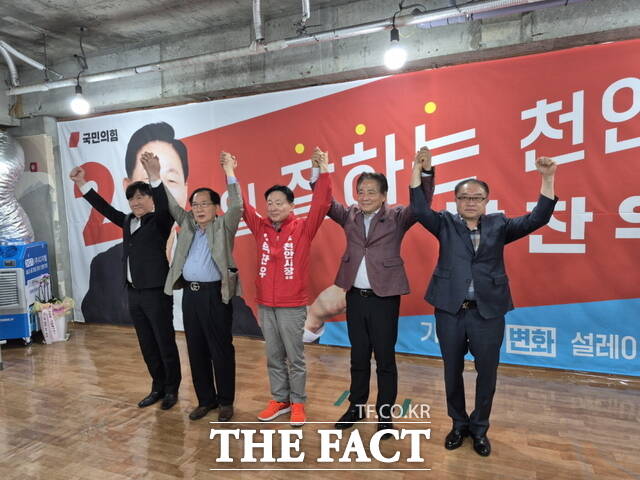 박찬우 국민의힘 천안시장 후보(가운데)와 황종헌 전 예비후보(왼쪽 네 번째)가 맞잡은 손을 들어 올리며 '원팀' 구성을 선언하고 있다. /박찬우 천안시장 후보 캠프