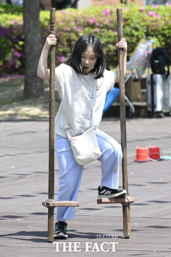 어린이들이 팽이치기를 하고 있다.