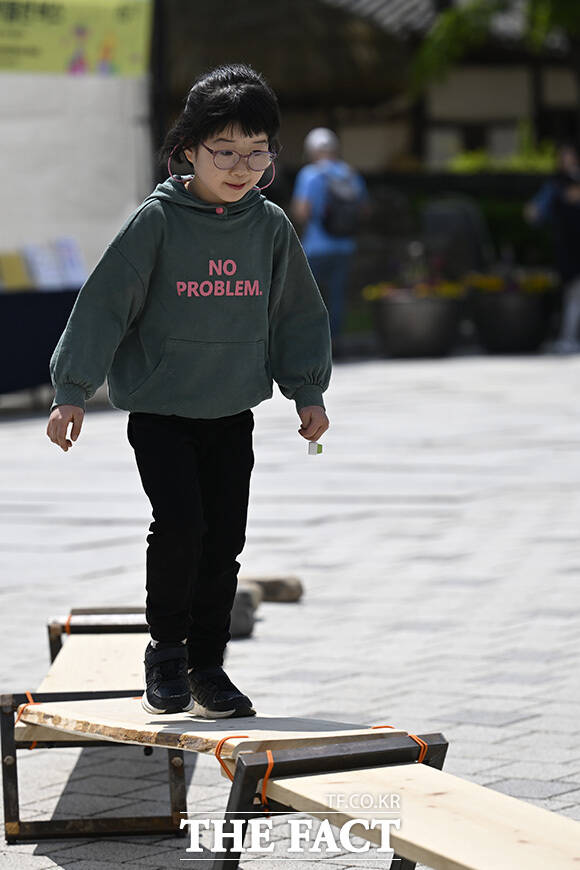 어린이들이 팽이치기를 하고 있다.
