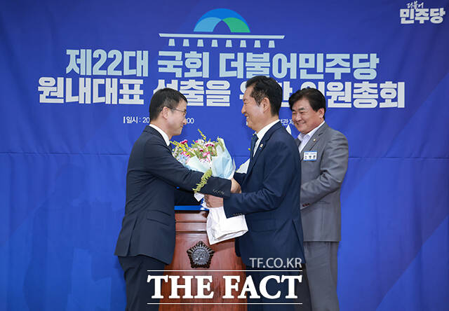 한병도 더불어민주당 전 원내대표(가운데)가 6일 오후 서울 여의도 국회에서 열린 제22대 국회 더불어민주당 원내대표 선출을 위한 의원총회에 참석해 당선을 확정지은 뒤 정청래 대표(오른쪽)에게 꽃다발을 선물받고 있다. /국회=배정한 기자