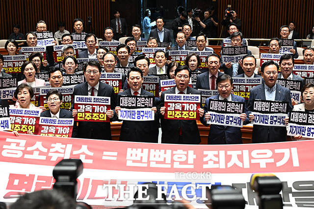 장동혁 국민의힘 대표와 송언석 원내대표(앞줄 네 번째부터) 및 의원들이 6일 오후 서울 여의도 국회에서 열린 의원총회에서 조작기소 특검법 규탄 대회를 열고 손피켓을 들어보이며 구호를 외치고 있다. /국회=남용희 기자