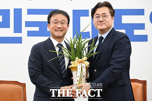 한병도 더불어민주당 원내대표(왼쪽)가 7일 오후 서울 여의도 국회에서 홍익표 청와대 정무수석을 만나 이재명 대통령 축하 난을 전달받은 뒤 기념촬영을 하고 있다. /국회=남용희 기자