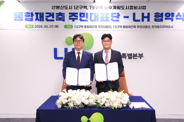 한국토지주택공사(LH)는 7일 군포산본 노후계획도시 특별정비예정구역인 12·13구역 주민대표단과 '2차 특별정비구역' 지정 추진을 위한 업무협약을 체결했다. 서울 수도권정비사업특별본부 대회의실에서 박현근 LH 수도권정비사업특별본부장(왼쪽)과 윤태호 산본13구역 주민대표단장(오른쪽)이 기념사진을 촬영하고 있는 모습. /LH