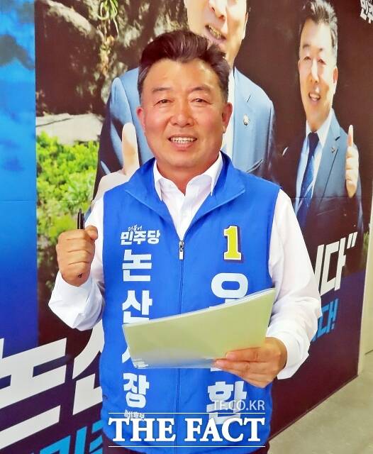 오인환 예비후보가 8일 논산시 선거사무소에서 <더팩트>와 인터뷰를 하고 대형 현수막 앞에서 필승을 외치고 있다. /김형중 기자