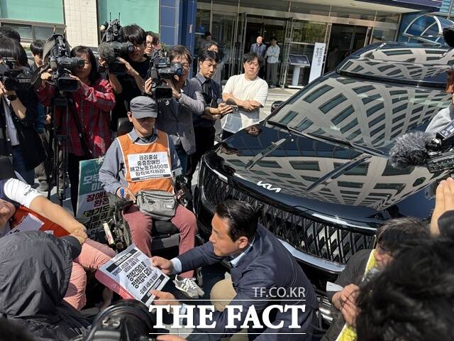 전장연이 오세훈 캠프 측에 '권리 중심 중증 장애인 해고노동자 400명을 원직 복직하라'는 내용이 담긴 정책간담회 및 정책협약 요청서를 전달했다. 사진은 전장연이 오세훈 캠프 차량을 막고 있는 모습이다. /문화영 기자