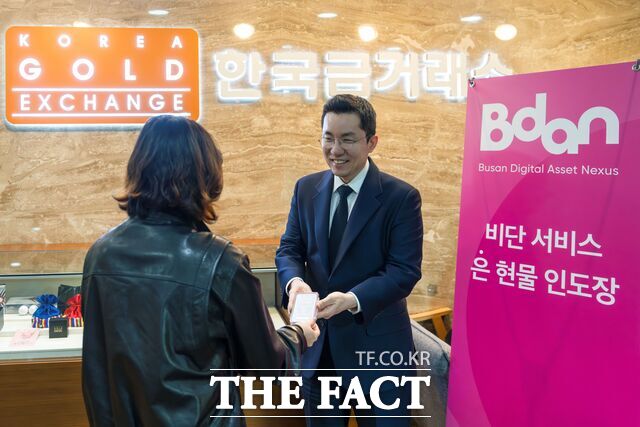 김상민(오른쪽) 부산디지털자산거래소 비단(Bdan) 대표가 실물교환을 신청한 고객에게 실버바를 인도하고 있다. /비단