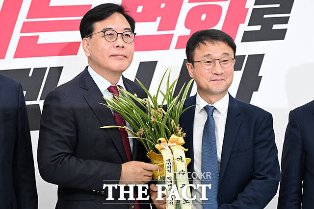 한병도 더불어민주당 원내대표(오른쪽)가 14일 오후 서울 여의도 국회에서 송언석 국민의힘 원내대표를 예방해 축하난을 받으며 기념촬영을 하고 있다. /국회=남용희 기자