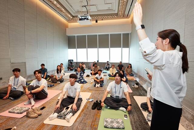 15일 서울 송파구 시그니엘 서울에서 열린 롯데 스키앤스노보드팀 워크숍 참석자들이 명상 요가 프로그램에 참여하고 있다. /롯데그룹