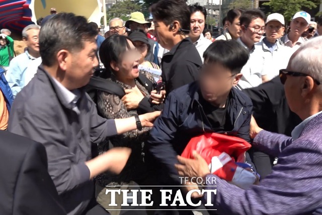 오세훈 국민의힘 서울시장 후보가 15일 서울 중구 청계천에서 이명박 전 대통령과 만나 대화를 나누던 중 한 남성이 기습 시위를 시도하다 저지당하고 있다. /청계천=김민지 기자