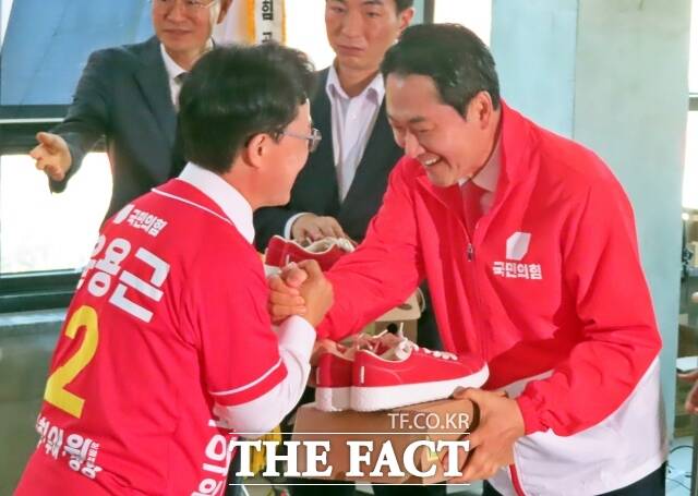 장동혁 대표가 윤용근 후보에게 필승하라고 운동화를 선물하고 있다. /김형중 기자