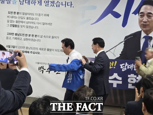 양승조 공동상임선대위원장이 박수현 충남도지사 후보에게 민주당 점퍼(후보자 이름과 직책이 새겨진 파란색 점퍼)를 입혀주고 있다. /정효기 기자