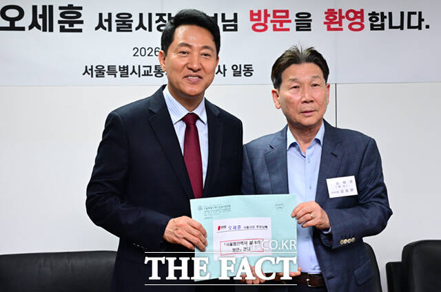 오세훈 국민의힘 서울시장 후보(왼쪽)가 20일 서울 송파구 교통회관에서 서울시개인택시운송사업조합원들의 정책제안서를 받고 있다. /이새롬 기자