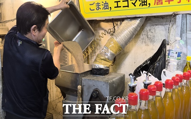 19일 낮 서울 중구 중부 건어물 시장 충북제유소 대표 최성환 씨가 일본어로 적힌 안내 표지판 아래 기계에서 기름을 내리고 있다. /서울 중구=오승혁 기자