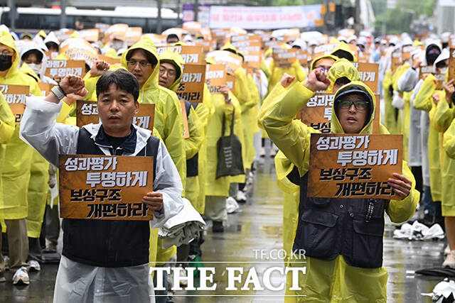 카카오 노조원이 비를 맞으며 '투명한 성과평가와 보상구조 개편'을 촉구하고 있다. /성남=남윤호 기자