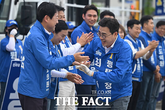 김용남 더불어민주당 평택을 국회의원 재선거 후보와 최원용 민주당 평택시장 후보를 비롯한 시·도 의원 후보들이 손을 맞잡고 인사하고 있다.