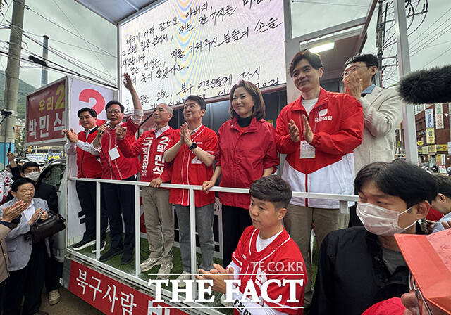박민식 국민의힘 부산 북구갑 국회의원 후보의 어머니(오른쪽)가 21일 오후 부산 북구 구포시장 인근 쌈지공원에서 열린 출정식에서 박 후보의 머리를 삭발하고 있다. /박민식 후보 캠프