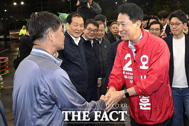 오 후보가 시장 상인과 악수를 하고 있다.