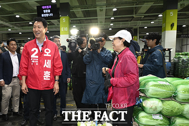 오세훈 국민의힘 서울시장 후보가 21일 오전 서울 송파구 가락농수산물종합도매시장을 방문해 시장 상인과 미소를 짓고 있다./송호영 기자