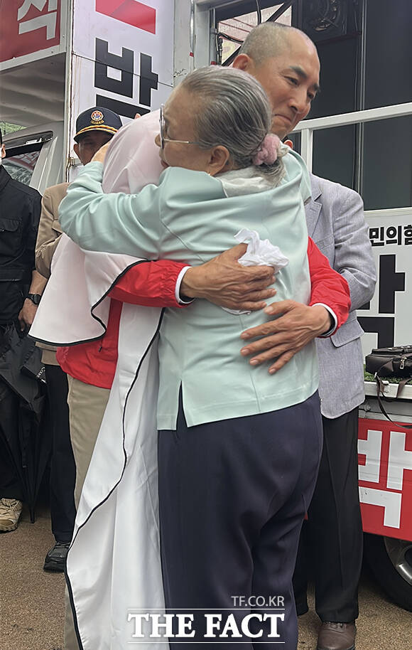 박민식 국민의힘 부산 북구갑 국회의원 후보의 어머니(오른쪽)가 21일 오후 부산 북구 구포시장 인근 쌈지공원에서 열린 출정식에서 박 후보의 머리를 삭발하고 있다. /박민식 후보 캠프