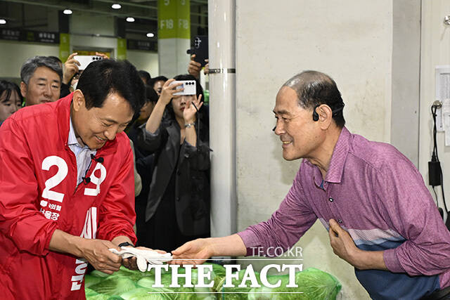 오 후보가 시장 상인과 악수를 하고 있다.