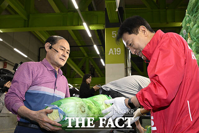 오 후보가 시장 상인과 악수를 하고 있다.