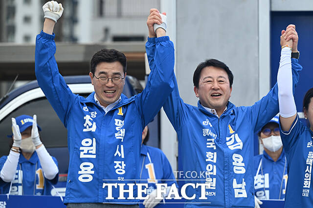 김용남 더불어민주당 평택을 국회의원 재선거 후보와 최원용 민주당 평택시장 후보를 비롯한 시·도 의원 후보들이 손을 맞잡고 인사하고 있다.