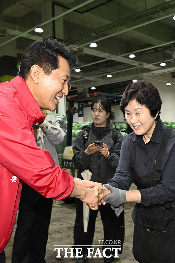오 후보가 시장 상인과 악수를 하고 있다.