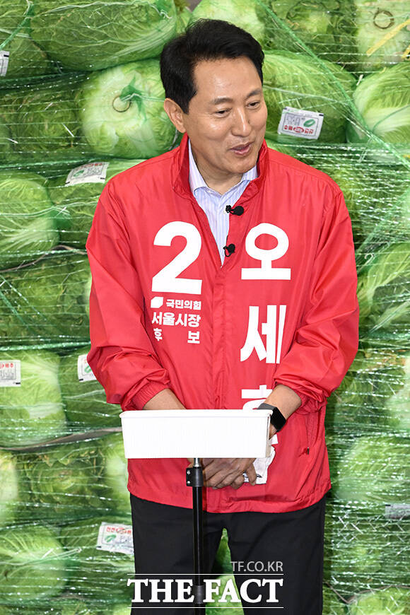 오 후보가 시장 상인과 악수를 하고 있다.