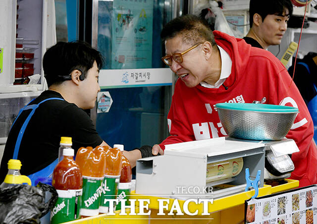 박형준 국민의힘 부산시장 후보(왼쪽)가 선거운동 둘째 날인 22일 오후 부산 중구 자갈치시장을 찾아 한 상인과 인사하고 있다. /부산=박상민 기자