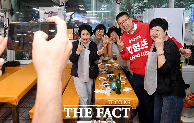 박형준 국민의힘 부산시장 후보(왼쪽)가 선거운동 둘째 날인 22일 오후 부산 중구 자갈치시장을 찾아 한 상인과 인사하고 있다. /부산=박상민 기자