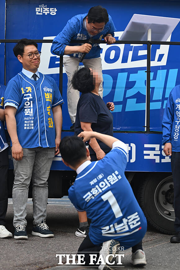 한 시민이 연설 중인 박찬대 후보에게 기념촬영을 요구하는 모습.