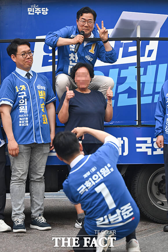 박찬대 더불어민주당 인천광역시장 후보가 22일 오후 인천 계양구 계양우체국 앞에서 열린 집중유세에서 연설하며 지지를 호소하는 가운데 한 시민이 휴대전화를 들고 기념촬영을 요구해 응하고 있다. 뒷모습은 사진 촬영에 나선 김남준 더불어민주당 계양을 보궐선거 후보. /인천=남윤호 기자
