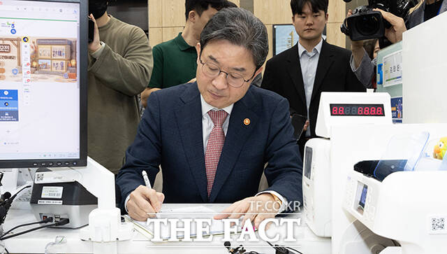 이억원 금융위원장(오른쪽)이 22일 오전 서울 종로구 NH농협은행 정부서울청사지점에서 직원으로부터 국민참여성장펀드에 대해 설명을 듣고 있다. /임영무 기자