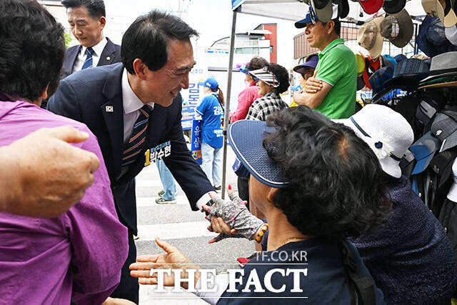 박수현 더불어민주당 충남도지사 후보가 22일 오전 충남 청양군 청양시장을 방문해 상인이 판매하는 노가리를 들어올리고 있다. /청양=김성렬 기자