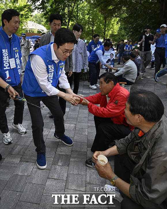 정 후보가 한 가족과 인사를 하고 있다.