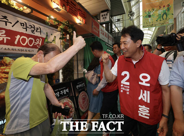 오세훈 국민의힘 서울시장 후보가 26일 서울 마포구 망원시장을 찾아 인사하는 도중 한 시민과 기념촬영하고 있다. /이새롬 기자