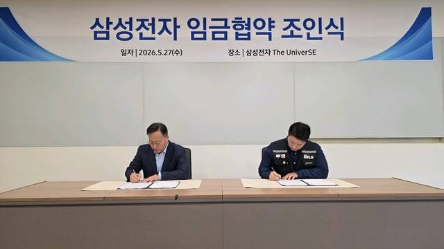 여명구 삼성전자 부사장(왼쪽)과 최승호 초기업노조삼성전자지부 위원장이 27일 경기 용인시 기흥 삼성전자 더 유니버스에서 열린 2026년 임금협약 조인식에 참석하고 있다. /삼성전자