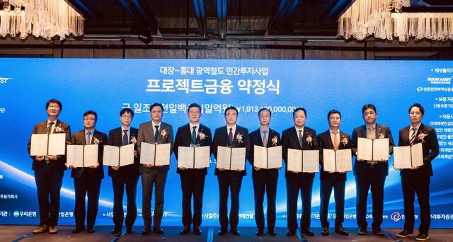 (왼쪽부터) 이형락 우리투자증권 전무, 조일연 현대로템 본부장, 이동현 기업은행 부장, 박정범 교보생명 본부장, 이명수 우리은행 IB그룹장, 이정한 서부광역메트로 대표이사, 이동훈 현대건설 사업부장, 김연식 한국산업은행 실장, 김선녕 한화생명 전무, 김방현 미래에셋자산운용 대표, 손진영 산은인프라자산운용 본부장이 지난 26일 서울 포시즌스호텔에서 금융약정을 체결한 뒤 기념촬영을 하고 있다. /우리은행
