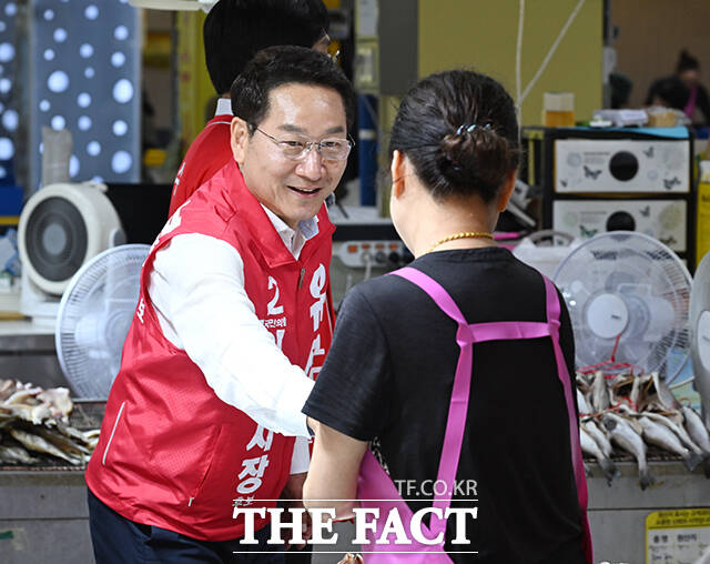유정복 국민의힘 인천시장 후보가 27일 오후 인천 강화군 강화풍물시장을 찾아 시장 상인과 인사를 나누고 있다. /강화=박헌우 기자