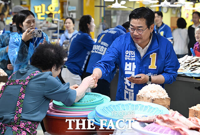 박찬대 더불어민주당 인천시장 후보가 27일 오후 인천 강화군 강화풍물시장을 찾아 상인과 인사를 나누고 있다. /강화=박헌우 기자