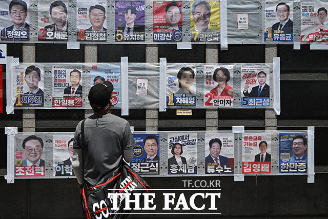 6·3 지방선거와 국회의원 재·보궐선거 사전투표를 하루 앞둔 28일 서울 마포구 망원역 앞에서 한 시민이 서울특별시장, 서울시교육감, 마포구청장 등 후보자들의 선거 벽보를 바라보고 있다. /남윤호 기자