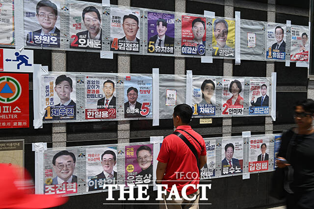 6·3 지방선거와 국회의원 재·보궐선거 사전투표를 하루 앞둔 28일 서울 마포구 망원역 앞에서 한 시민이 서울특별시장, 서울시교육감, 마포구청장 등 후보자들의 선거 벽보를 바라보고 있다. /남윤호 기자