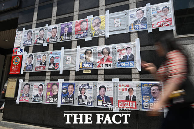 6·3 지방선거와 국회의원 재·보궐선거 사전투표를 하루 앞둔 28일 서울 마포구 망원역 앞에서 한 시민이 서울특별시장, 서울시교육감, 마포구청장 등 후보자들의 선거 벽보를 바라보고 있다. /남윤호 기자